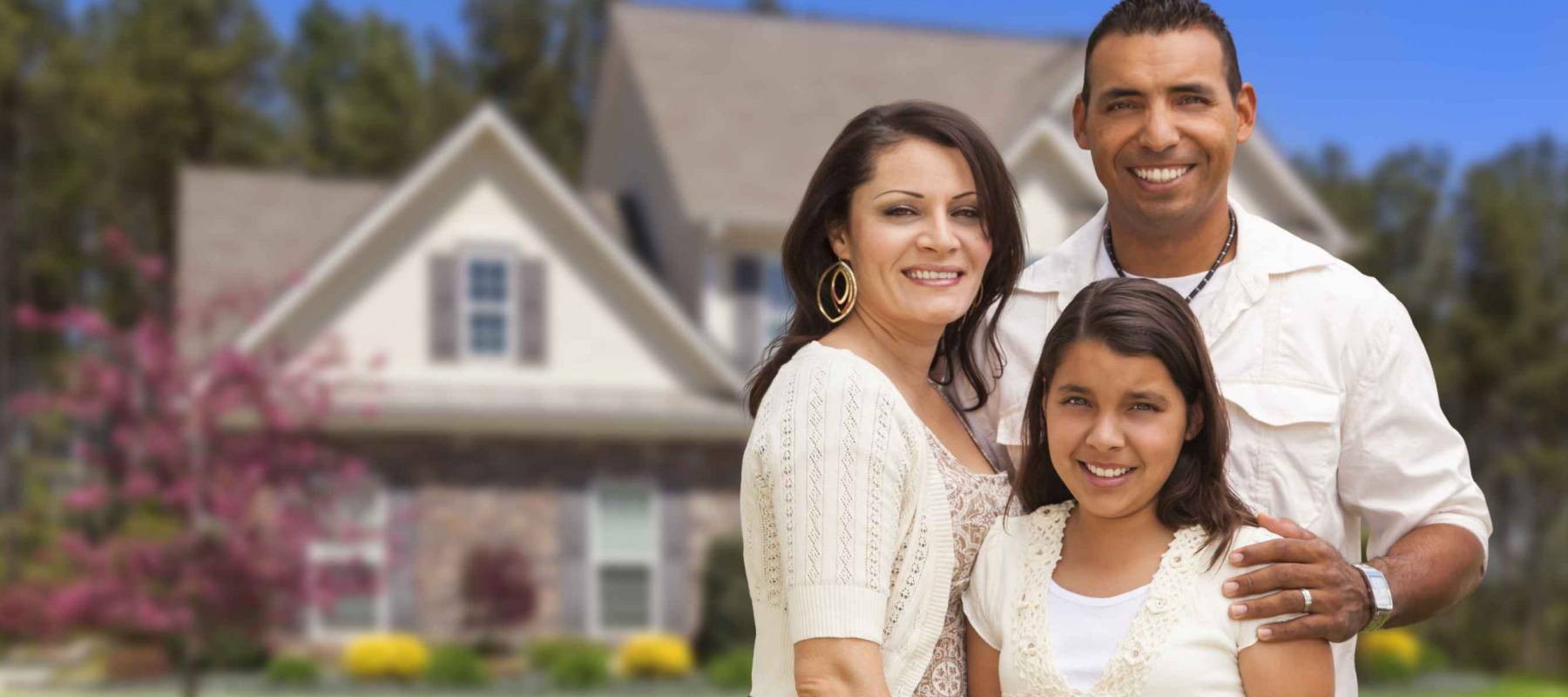 Happy Hispanic Mother, Father and Daughter in Front of Their Home.