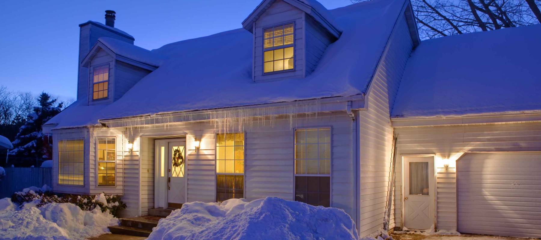 Typical American home with icy winter snow - evening twilight - cape cod style