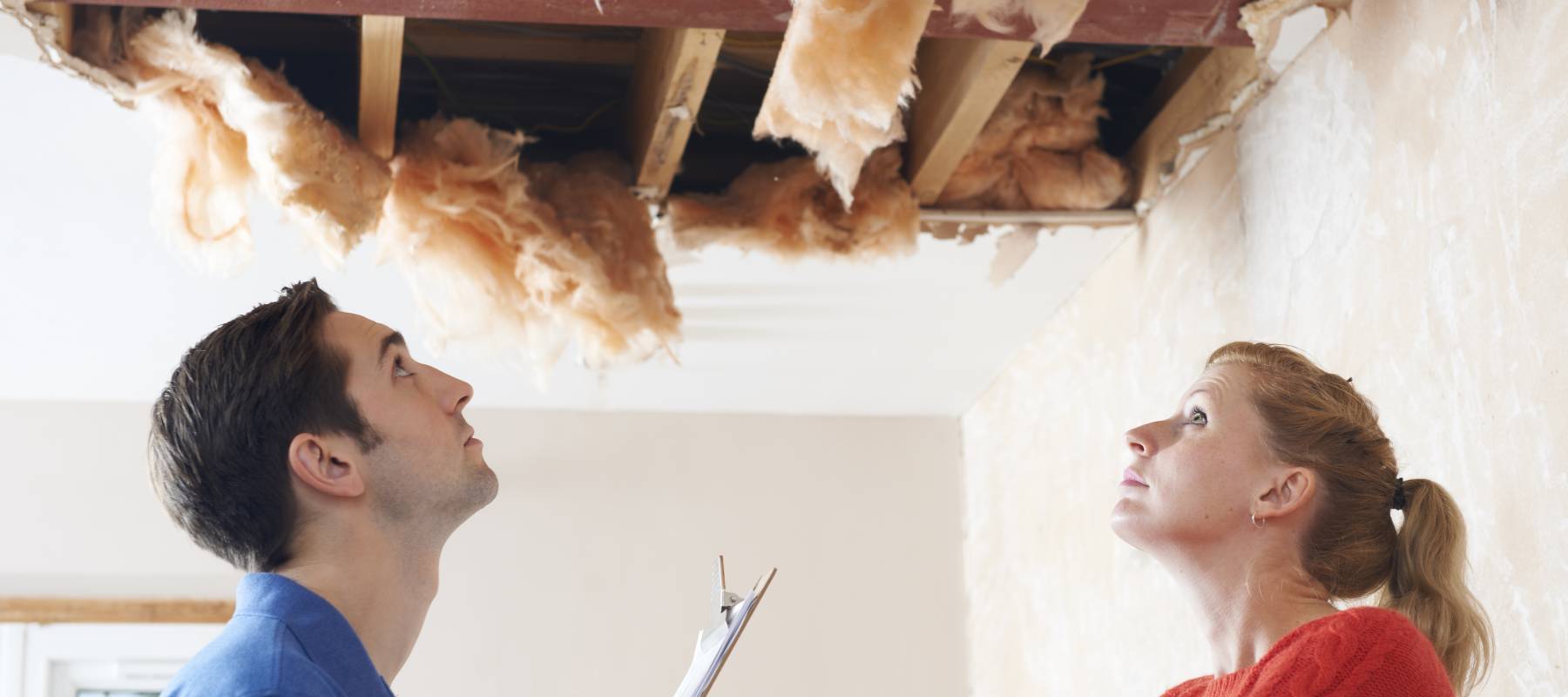 Builder And Client Inspecting Roof Damage
