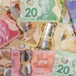 Canadian money paper bills and cash in a pile background. Learning to save money and keep a budget