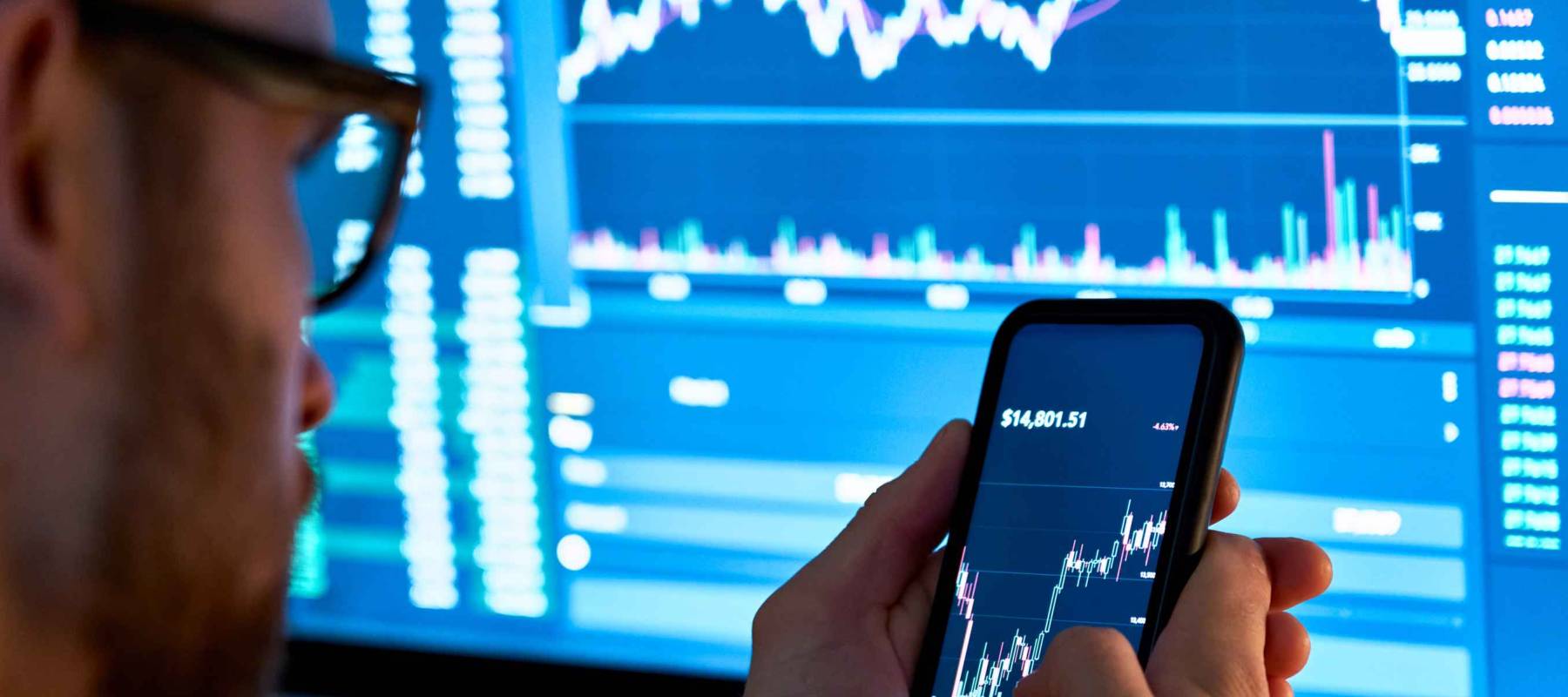 Caucasian man holding cellphone with stocks