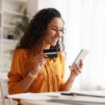 Mobile Shopping. Cheerful Arabic Woman Using Smartphone Shopping Online Holding Credit Card