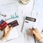 Stressed young woman calculating monthly home expenses, taxes, bank account balance and credit card bills payment, Income is not enough for expenses