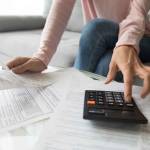 Woman renter holding paper bills using calculator for business financial accounting calculate money bank loan