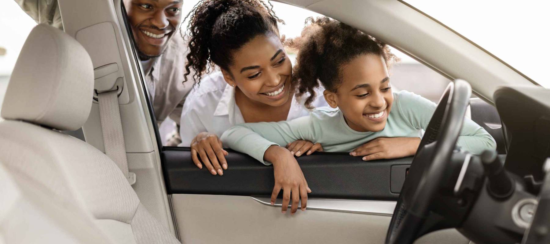 Cheerful Black Family Of Three Buying New Car, Looking Through Window At Auto Interior Choosing Luxury Automobile In Dealership. Vehicle Rent And Purchase Concept