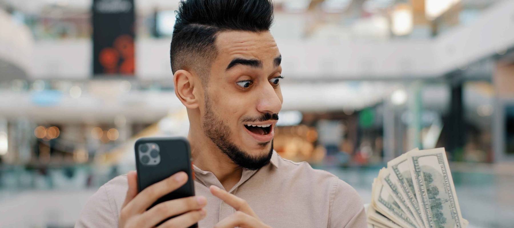 A South Asian man using his phone to get quick cash.