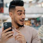 A South Asian man using his phone to get quick cash.