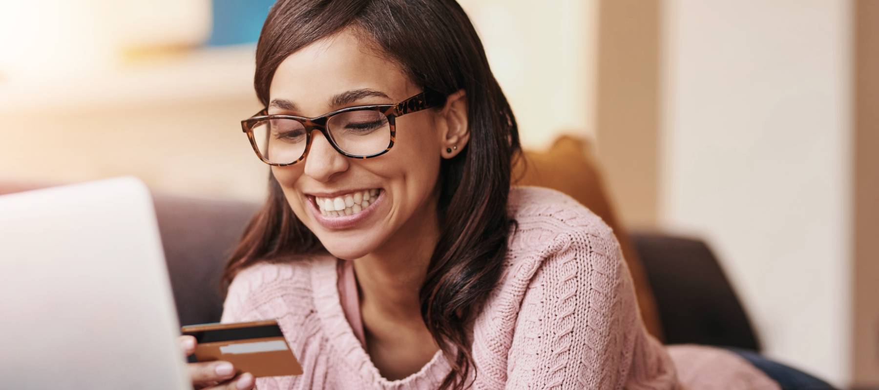 Young woman using credit card to pay bills online