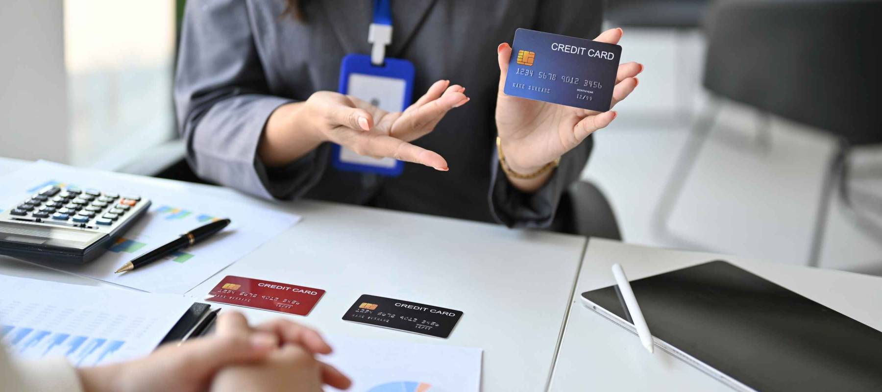 Close-up image of a professional female banker explaining the privileges of a new credit card to her potential customer during the meeting. financial and business concept