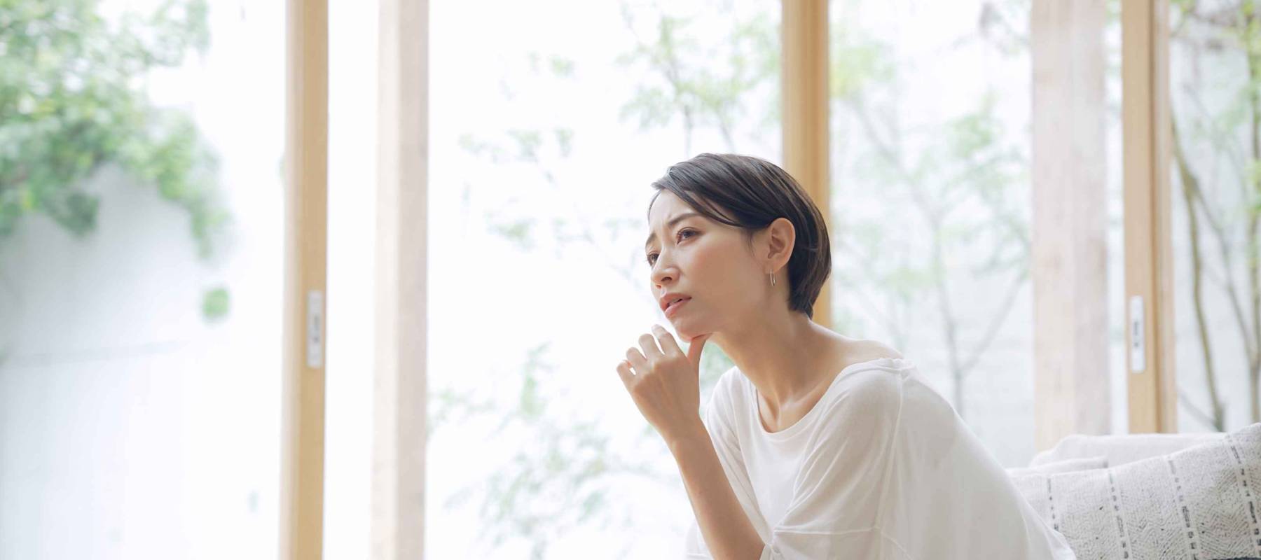 Wondering, curious Asian middle aged woman staring at the window.