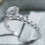 Close up of diamond ring with white flower, sunlight and shadow background. Love, valentine, relationship and wedding concept. Soft and selective focus.