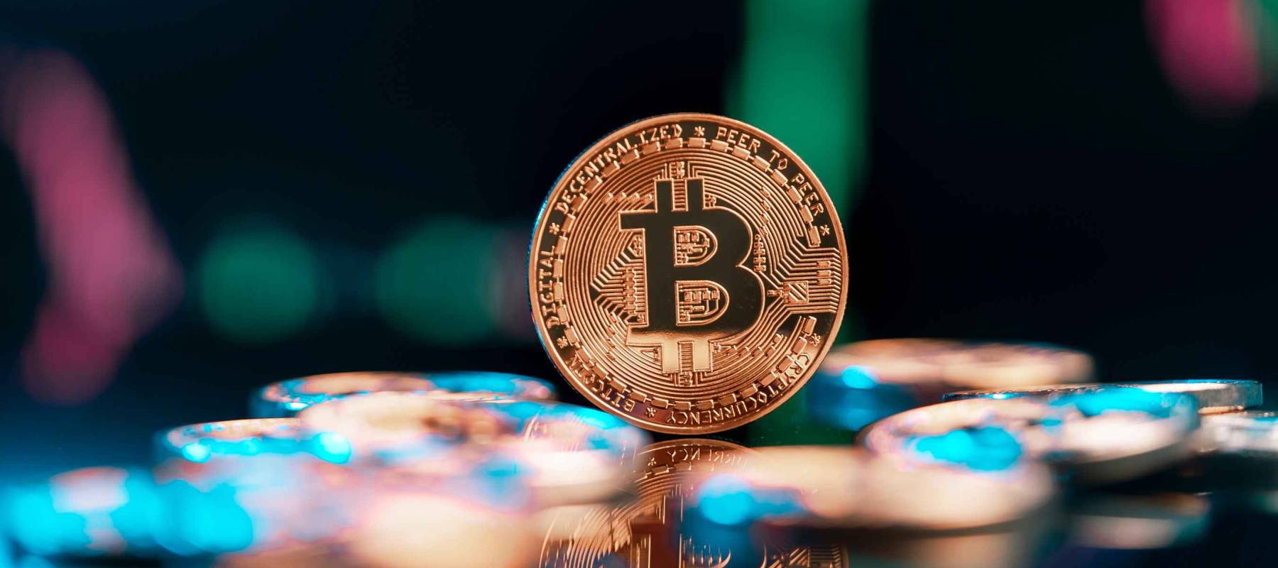 Bitcoin cryptocurrency with colorfull blurred candlestick chart in the background and reflection