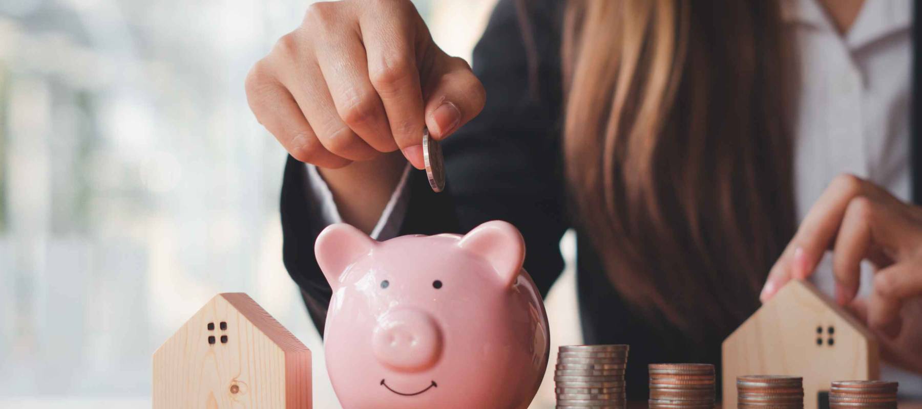 A woman's hand holds a coin to manage money and Plan your savings to buy the best home for your family, ideas for savings, growth, economy, business and investing.