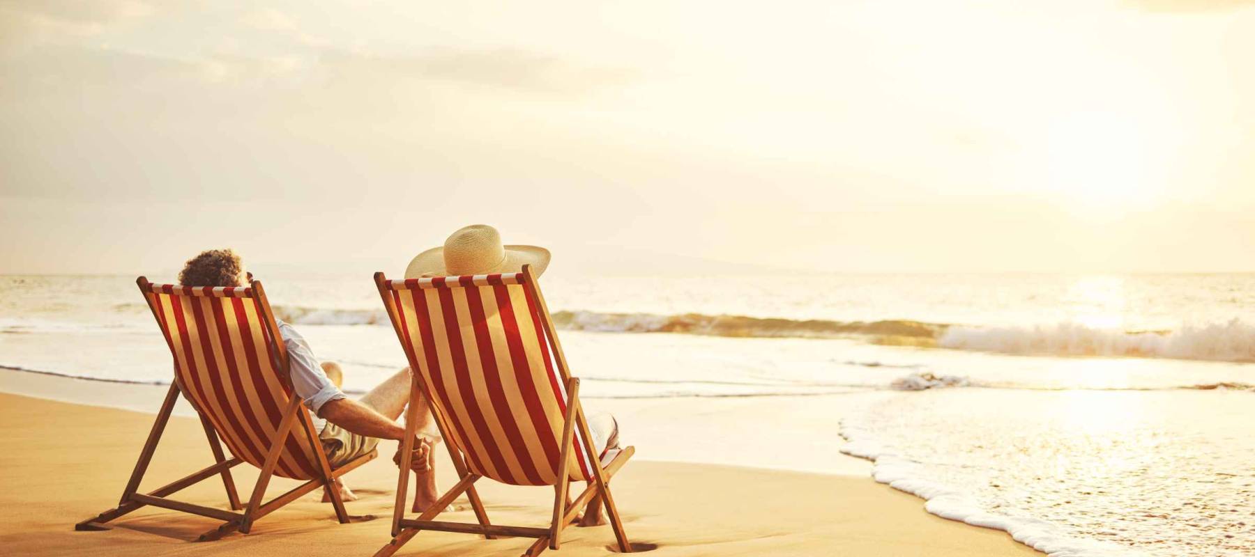 Retired couple watching sunset in vintage beach chairs