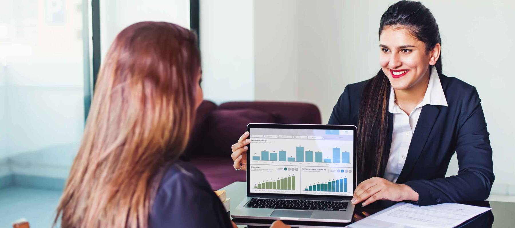 Investment consultant - Indian woman in formal suit, showing fund performance report with graphs on the laptop screen