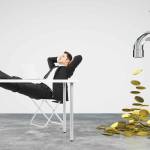 Money dripping concept with faucet and businessman resting on a chair