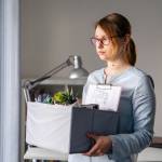 Woman with banker's box full of office supplies