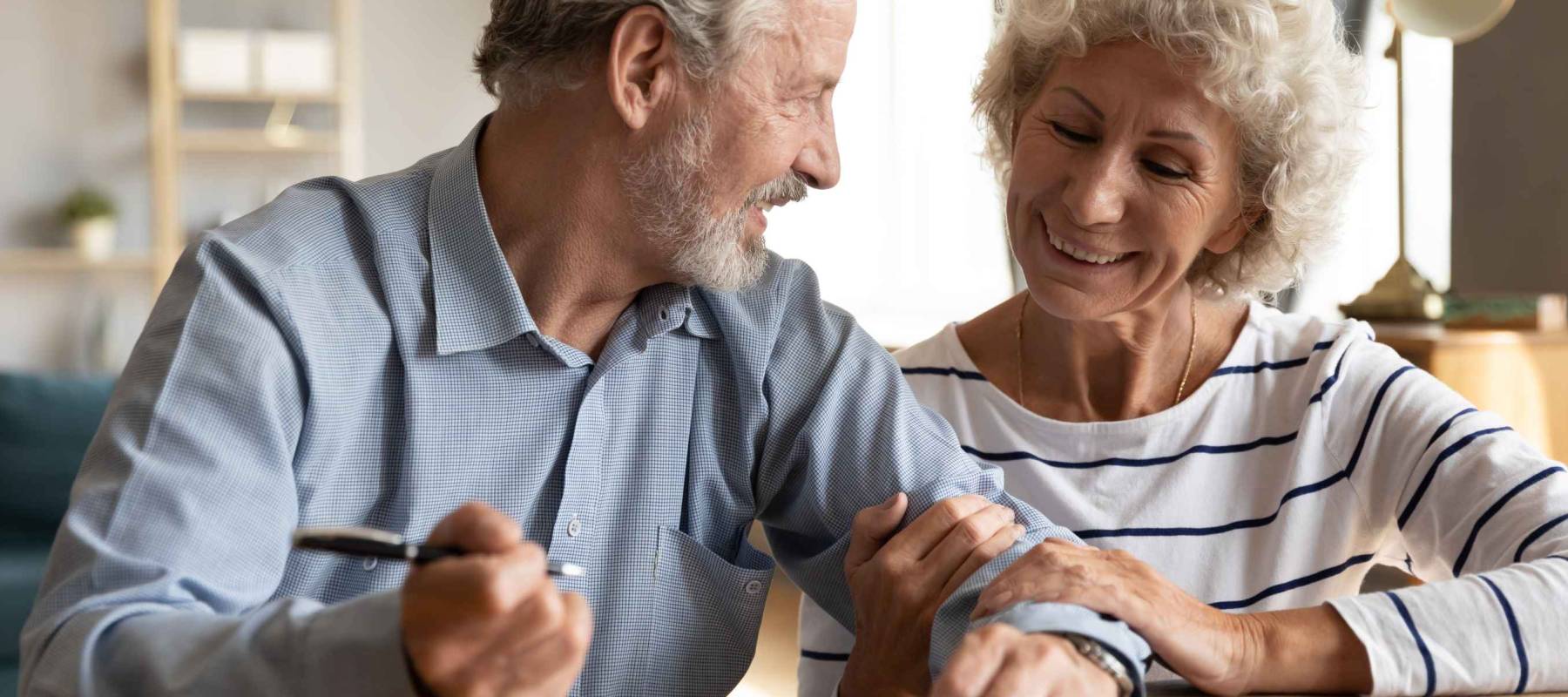 70s couple sit at table indoor discuss agreement term and conditions of their will