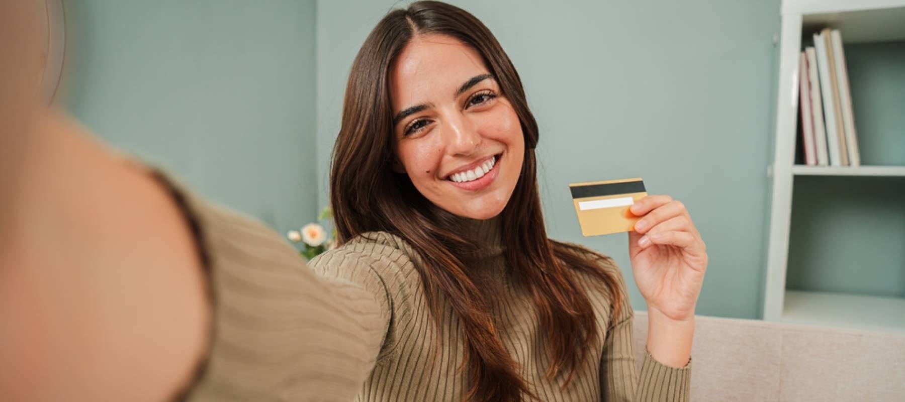 Woman holding credit card and smiling