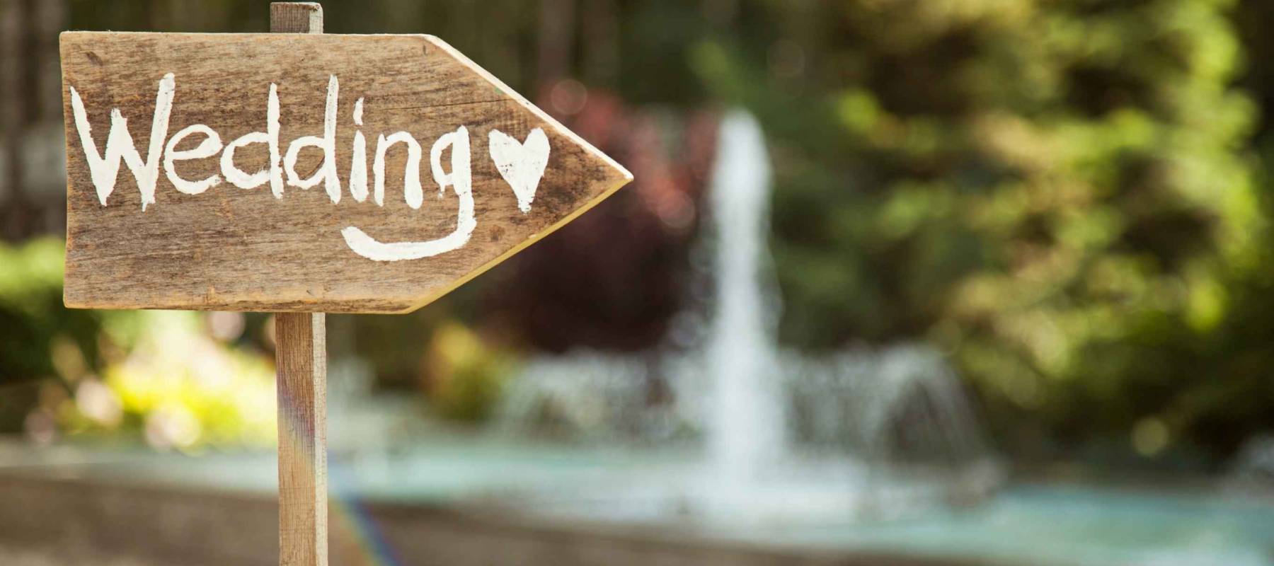 Wedding decor. Wooden plaque with the inscription Wedding. Wedding on a plate green background and a fountain. Wedding decorations,