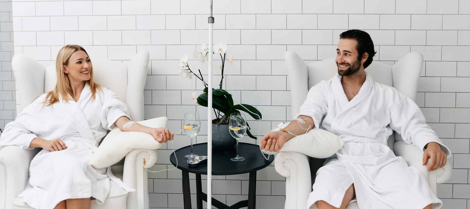 Maintenance and restoration of human immune system with vitamin IV infusion therapy. Beautiful woman with her boyfriend in modern wellness center during intravenous vitamin therapy.