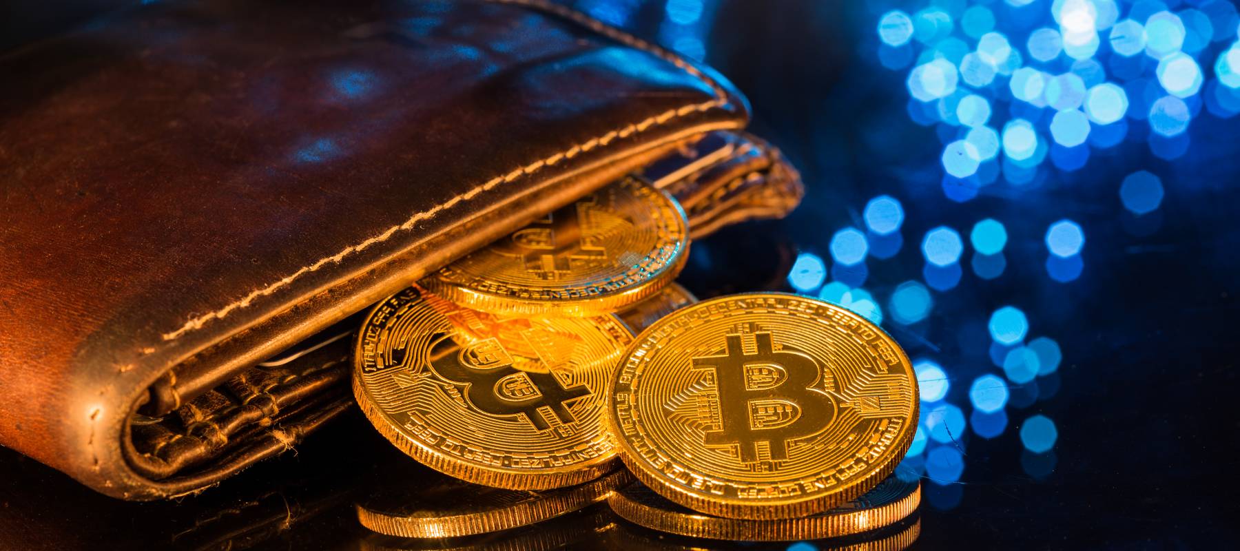 Bitcoin gold coins with wallet, close-up. Virtual cryptocurrency concept.