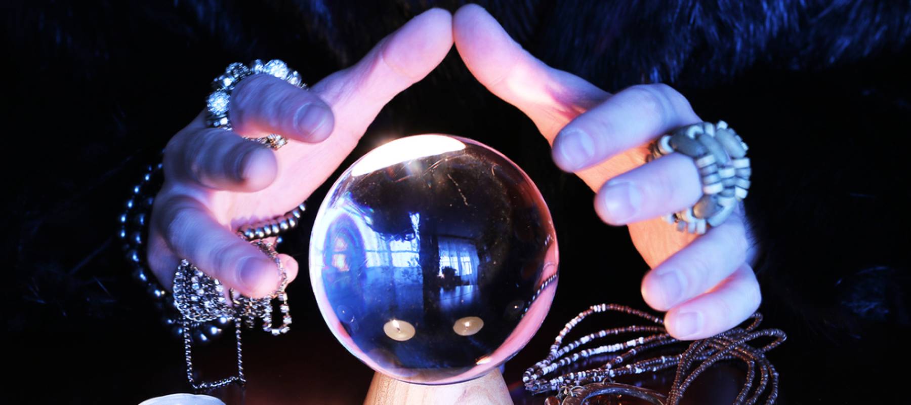 Fortune teller with hands around crystal ball