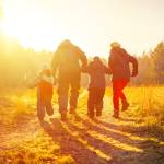 Happy family  running on country road in autumn time