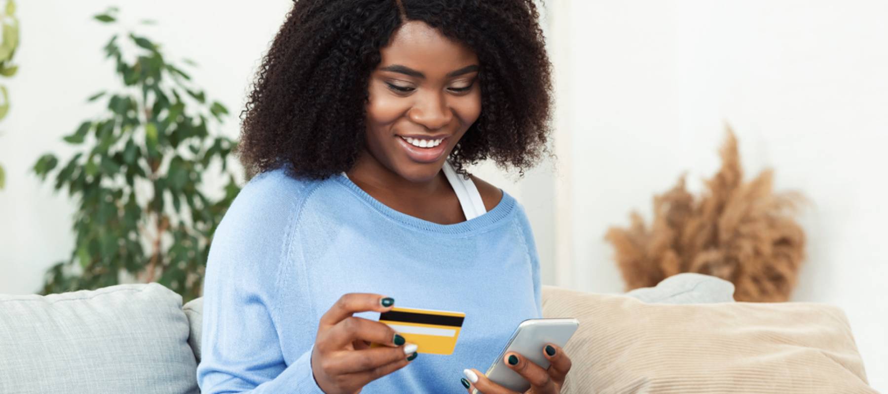 Woman using credit card on mobile phone