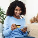 Woman using credit card on mobile phone