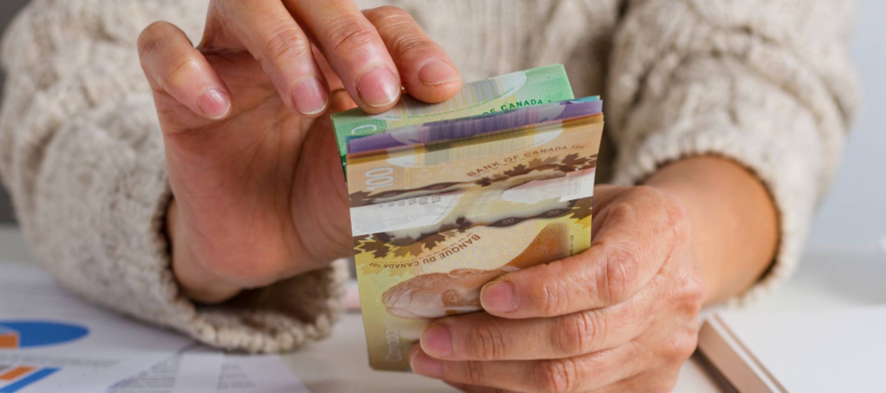 Person handling various Canadian bills