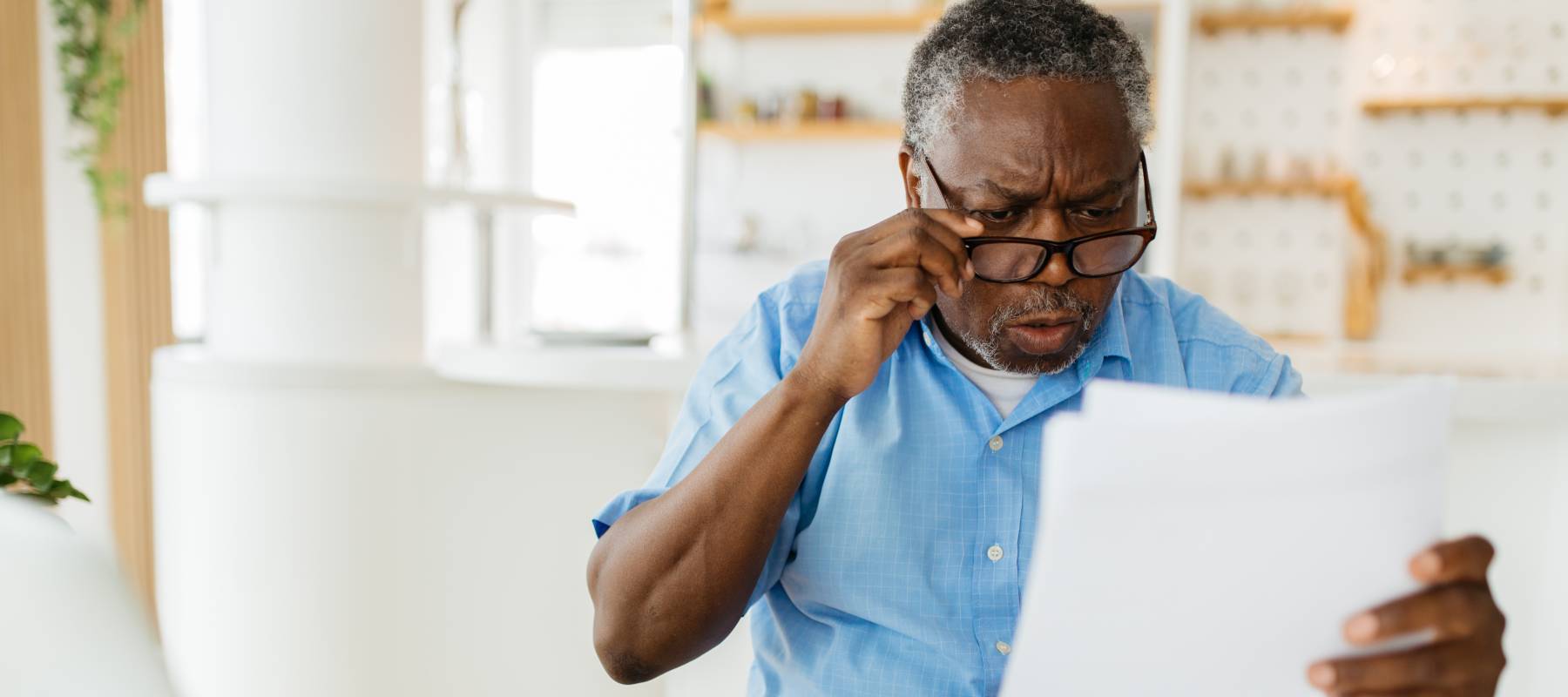 Older man looking surprised and concerned at documents