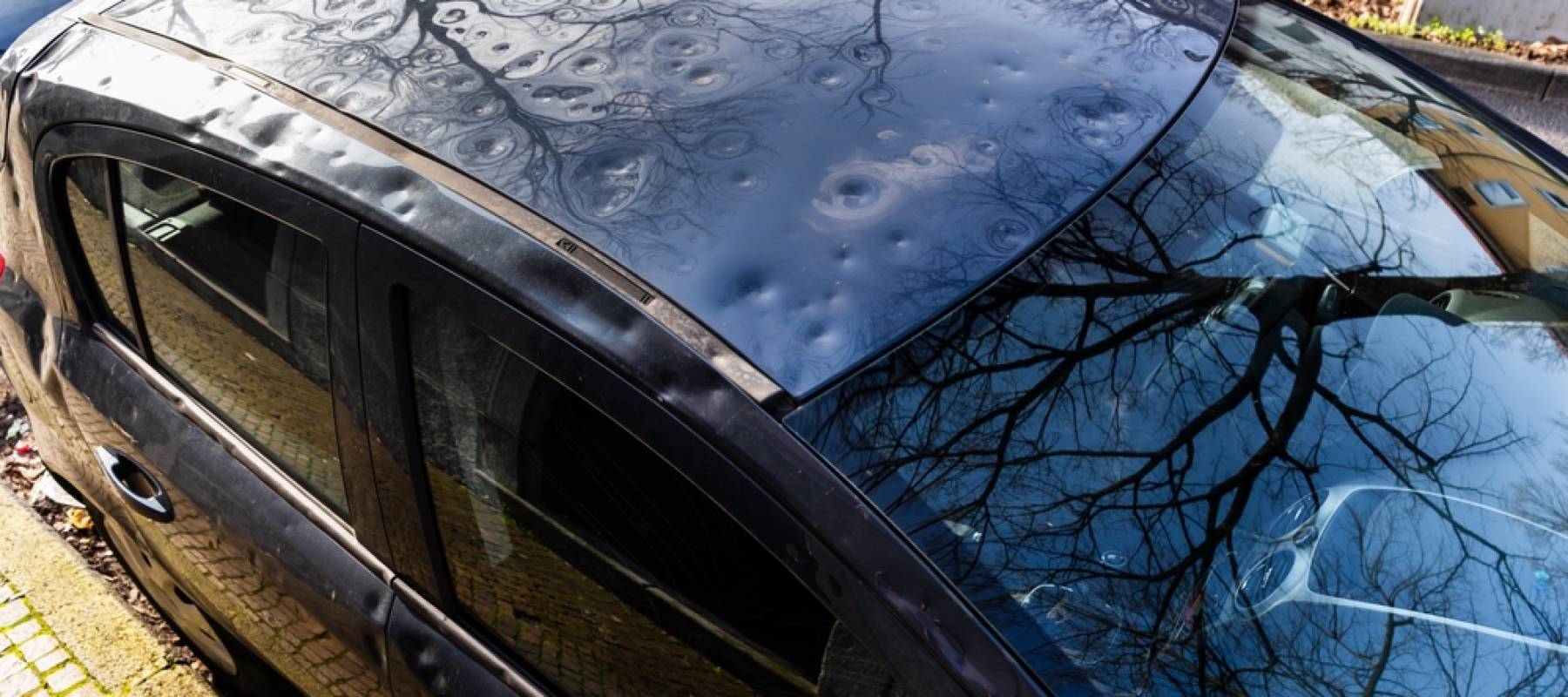 Roof of car dented by hail