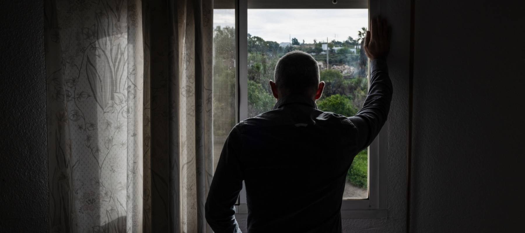 Man looking outside window