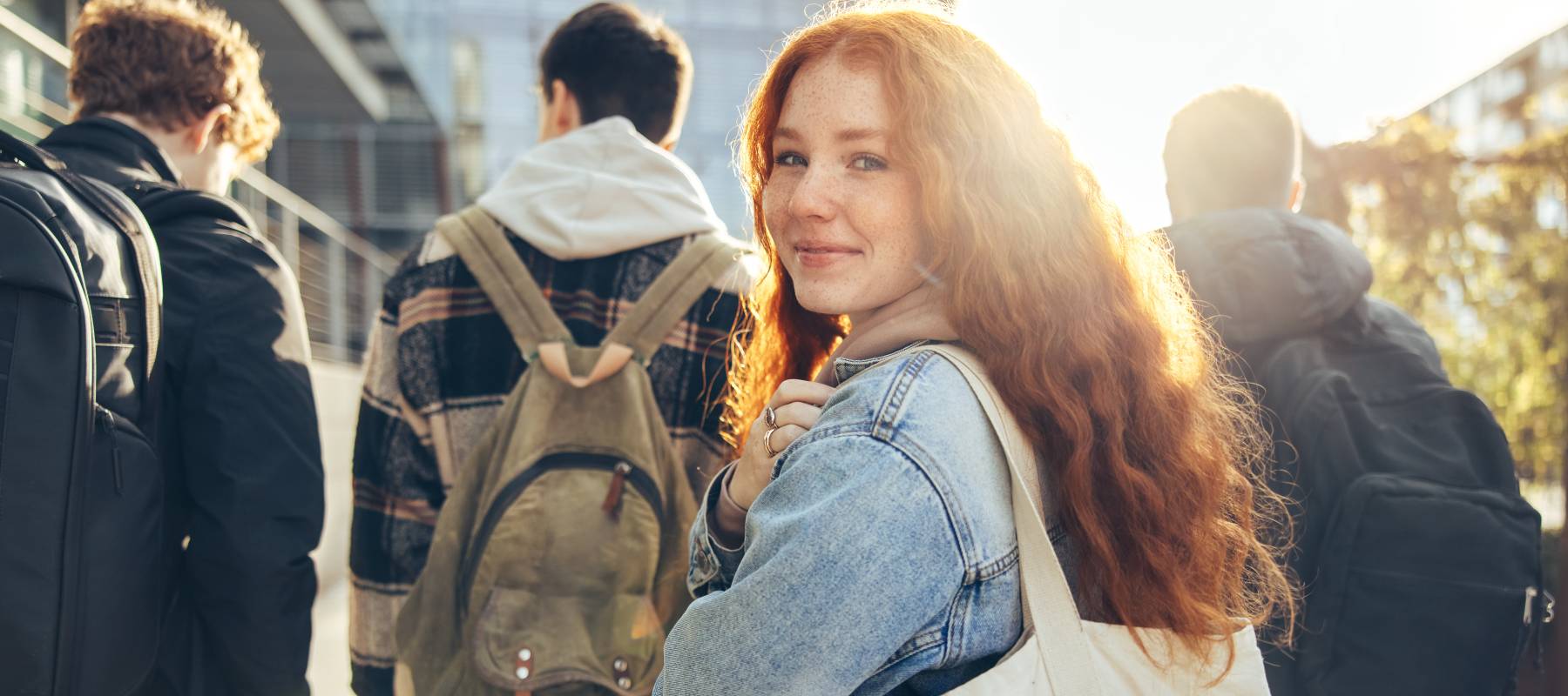 Female student glancing back while going for a class in college.
