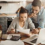 Young couple going over their bills at home in the kitchen