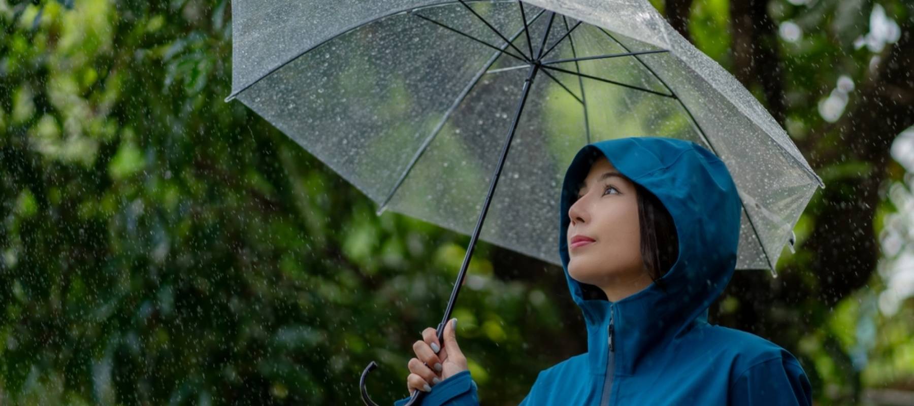 Woman under umbrella sheltering from a storm