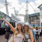 Two Taylor Swift fans pose in front of concert stadium