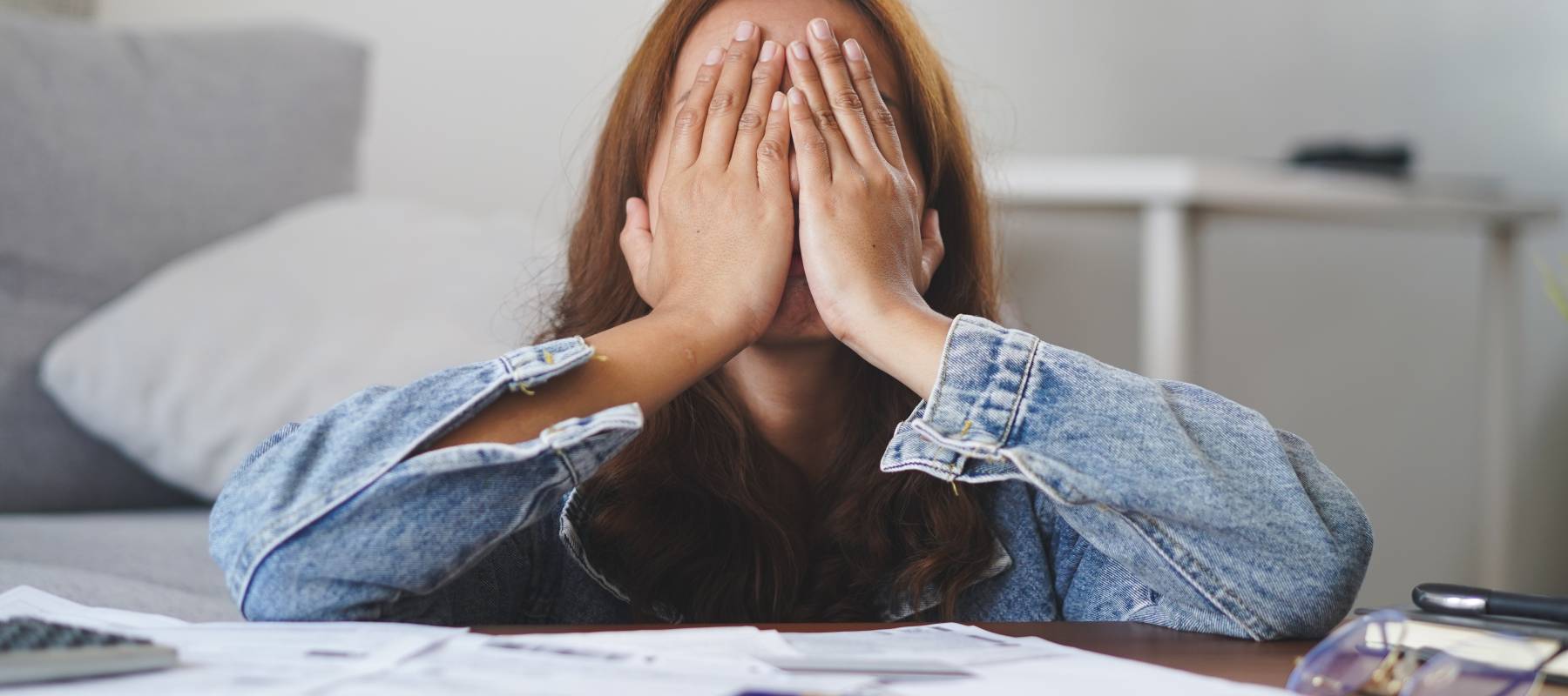 Young exasperated woman covering her face