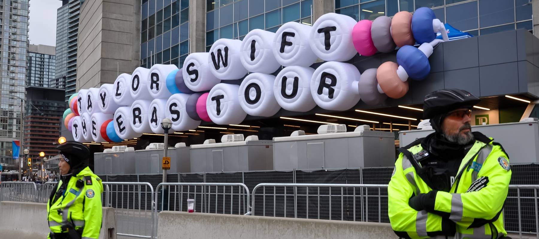 Toronto, Canada - November 14, 2024: Policemen in front of Taylor Swift The Eras Tour sign in Roger's Centre Toronto.