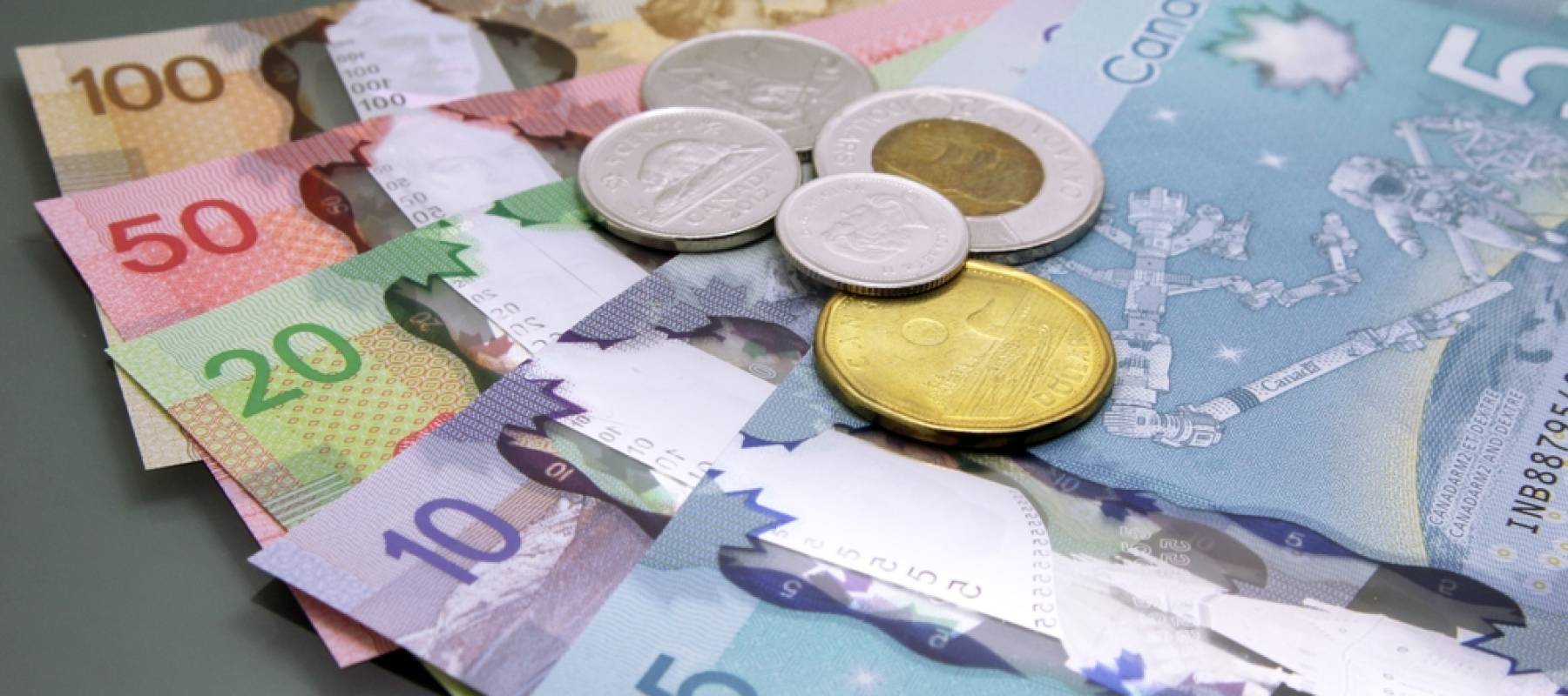 Stack of cash Canadian dollars on dark background.