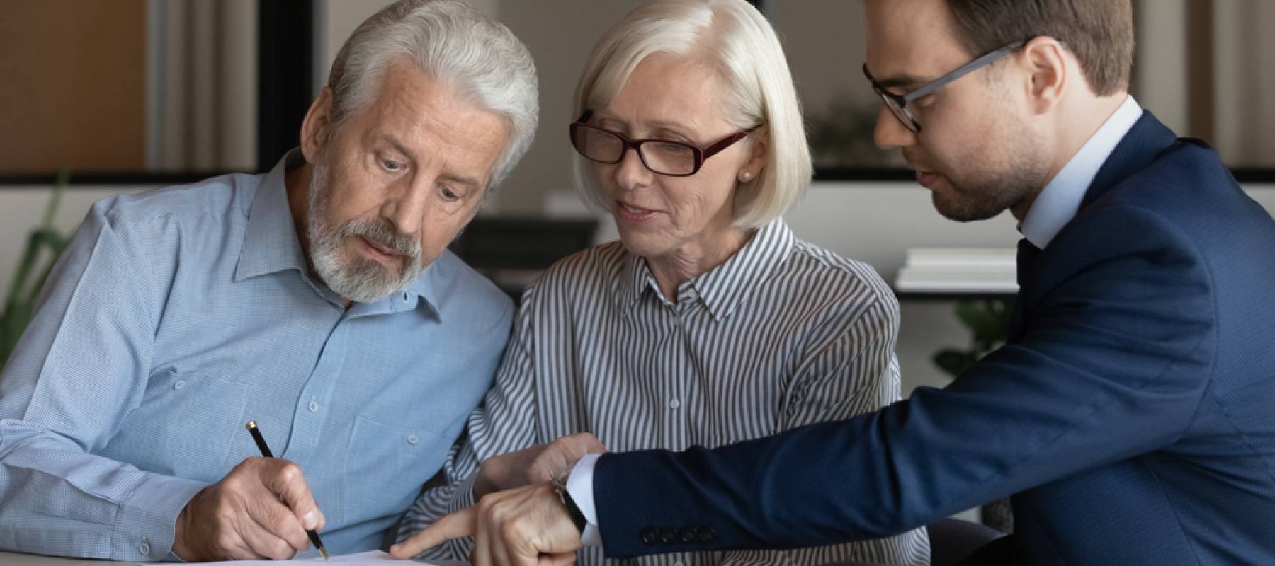 Middle-aged couple clients put signature on paper document