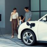 Progressive young parents and daughter with electric vehicle and home charging station.