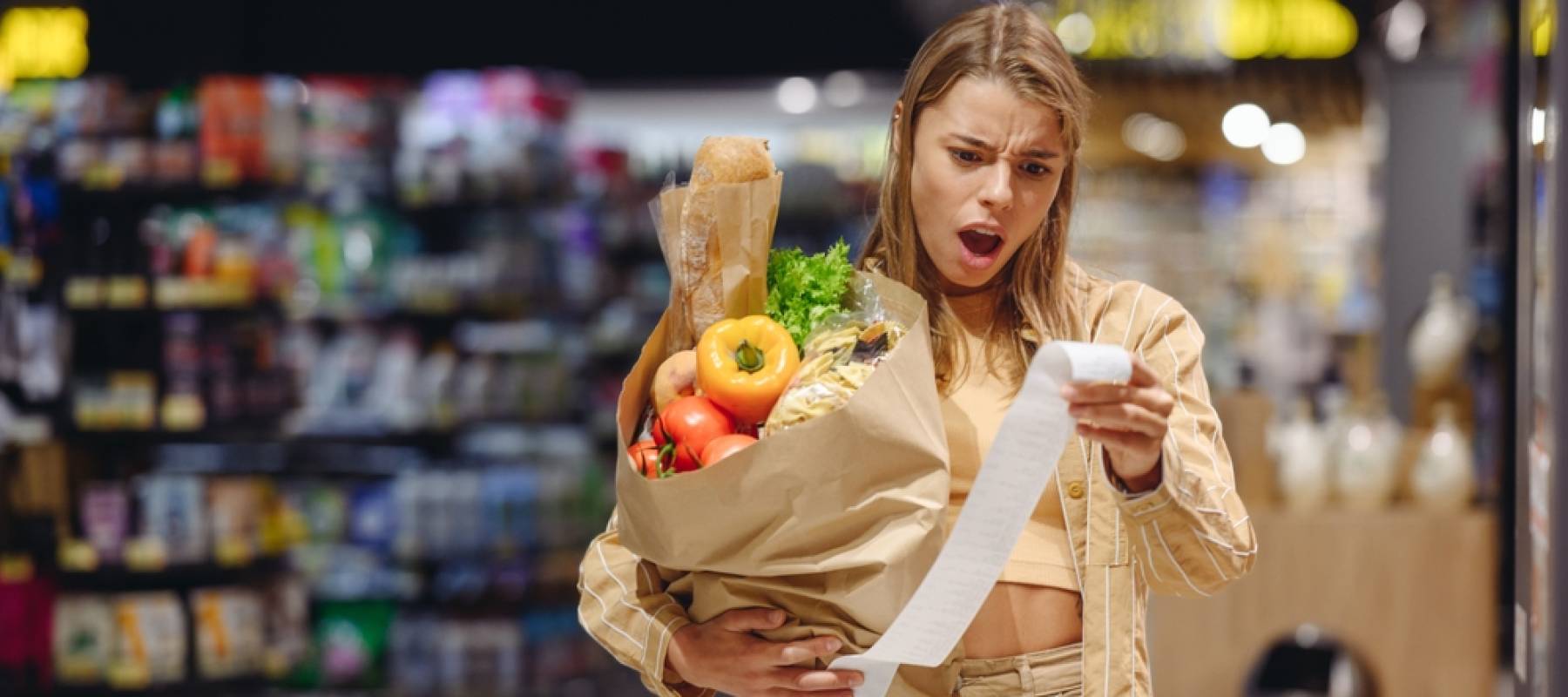 Woman looking surprised at grocery bill