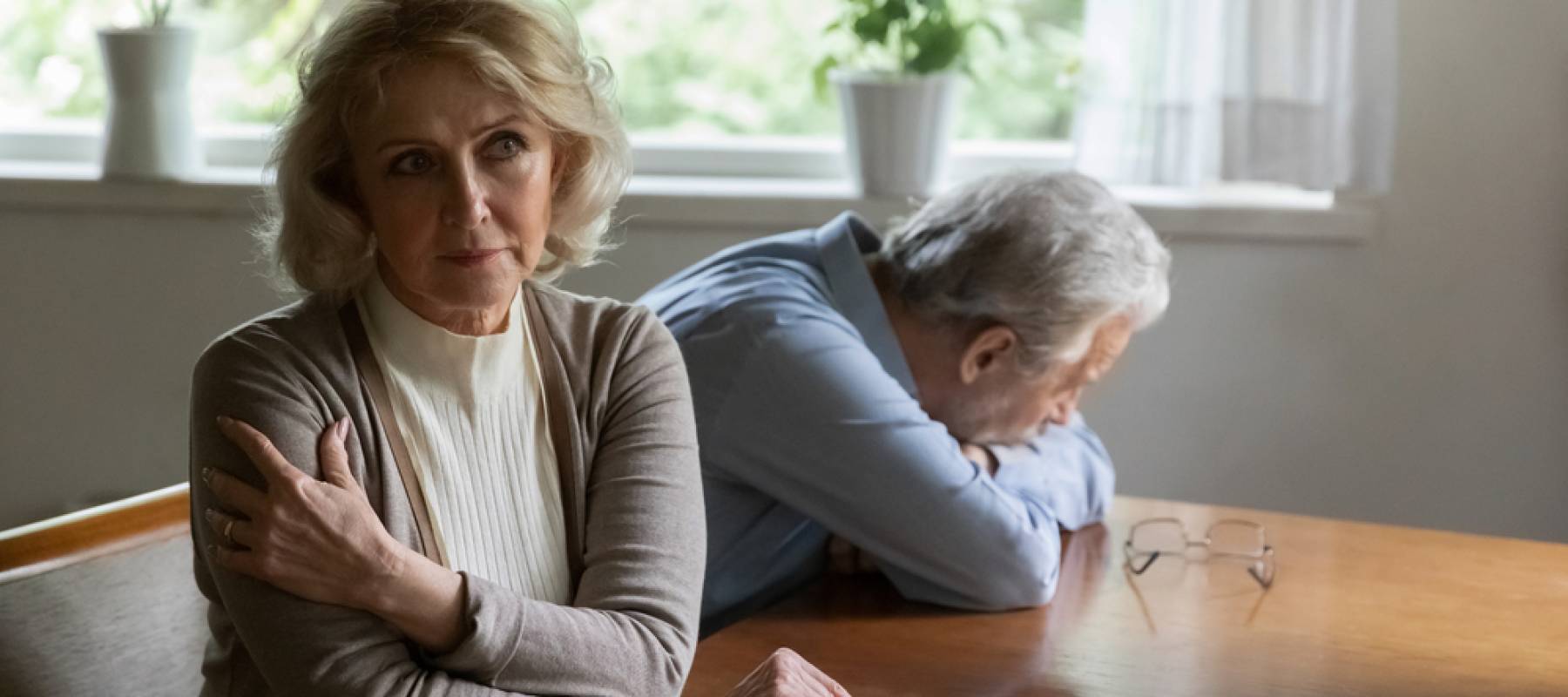 Older woman looking pensive and husband looking sad