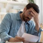 Upset frustrated young man reading bad news