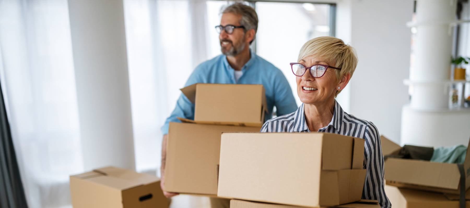 Happy retired senior couple moving into a new home, apartment.