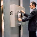 A bank employee closes closes the door of the vault.