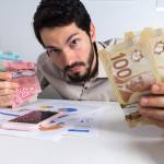 Man holding lots of Canadian bills