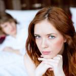 Young couple with an unhappy, attractive woman looking at the camera